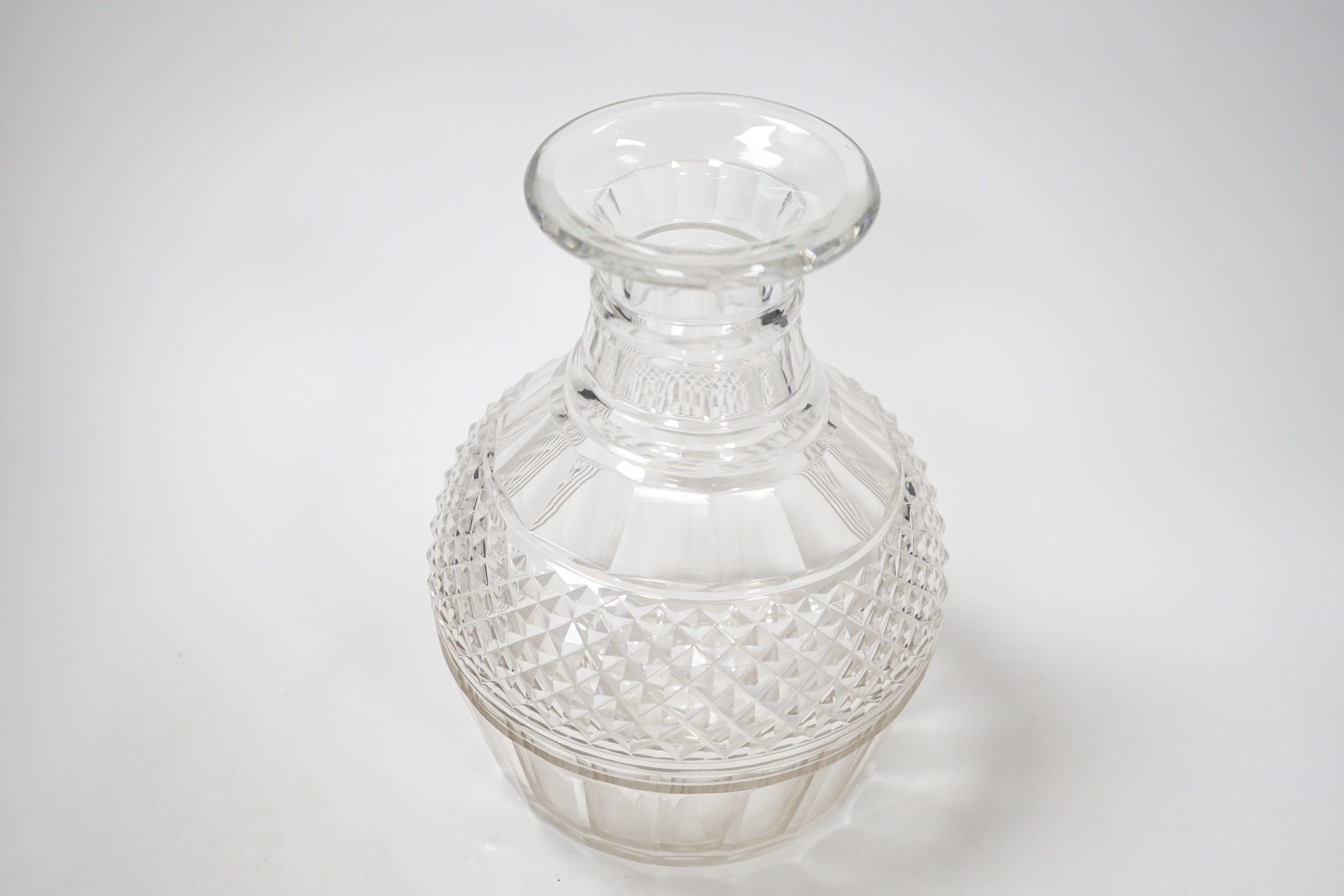 An English lead crystal Regency carafe, three rows of square cut facets alternate with two cut rings above a wide band of hobnails and further basal cut facets, ground and polished pontil, 20cm high